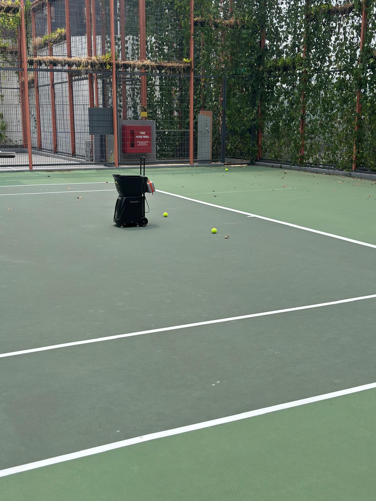 Ball machine on the court with tennis balls ready for practice